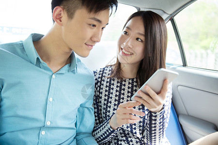 车内科技素材青年情侣在车内看手机背景