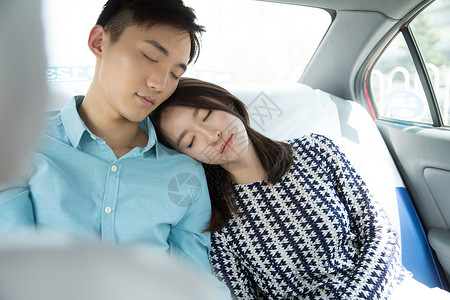 交通疲劳的青年情侣坐在车里睡觉图片
