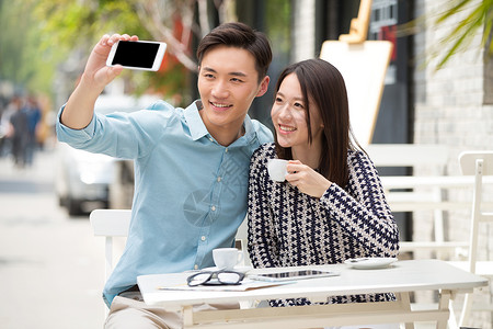 网红街拍青年情侣用手机自拍背景