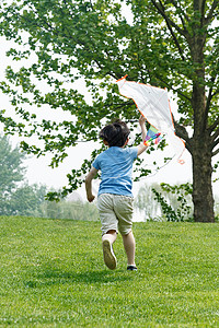 男孩在放风筝放假的小朋友们在公园玩闹背景