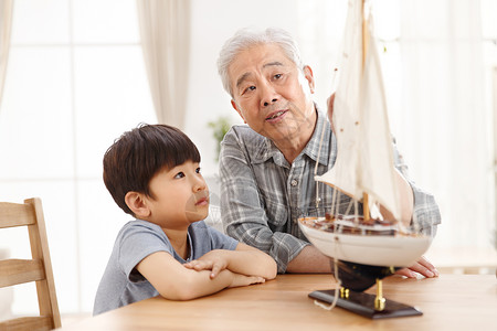 航海男孩祖父和孙子在客厅玩耍背景