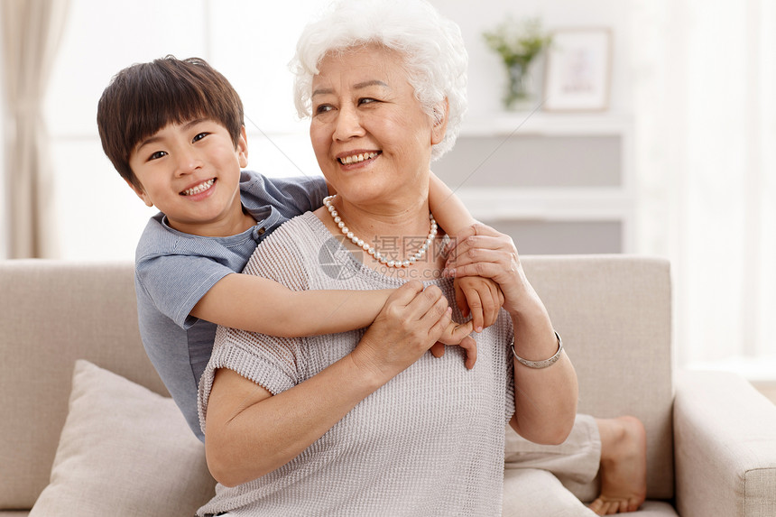 休闲拥抱亚洲可爱的小男孩和祖母在客厅图片