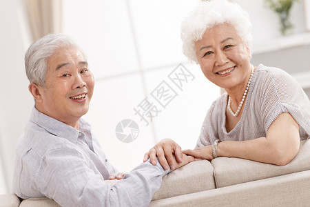 相伴深情的东亚幸福的老年夫妇在客厅微笑高清图片素材