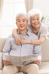 注视镜头两个人人老心不老幸福的老年夫妇在客厅住宅房间高清图片素材