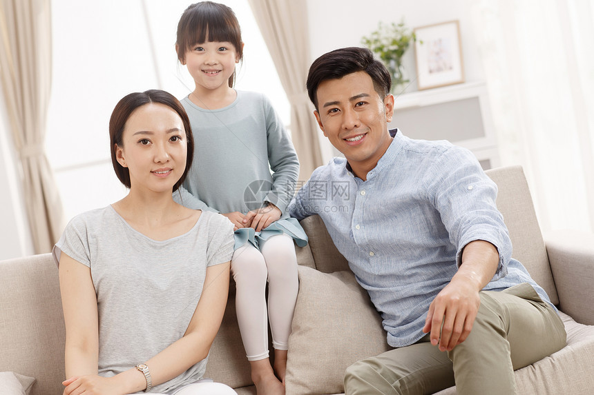 家庭幸福的一家三口坐在客厅里图片