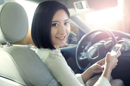 驾驶座信心汽车内部青年女人坐在汽车里看手机商务人士高清图片素材