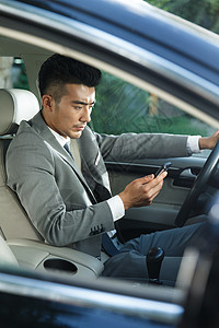 商务能力商务青年男人开车看手机背景
