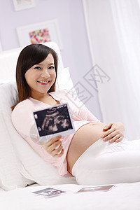简单彩色图片亚洲孕妇拿着超声波照片图片