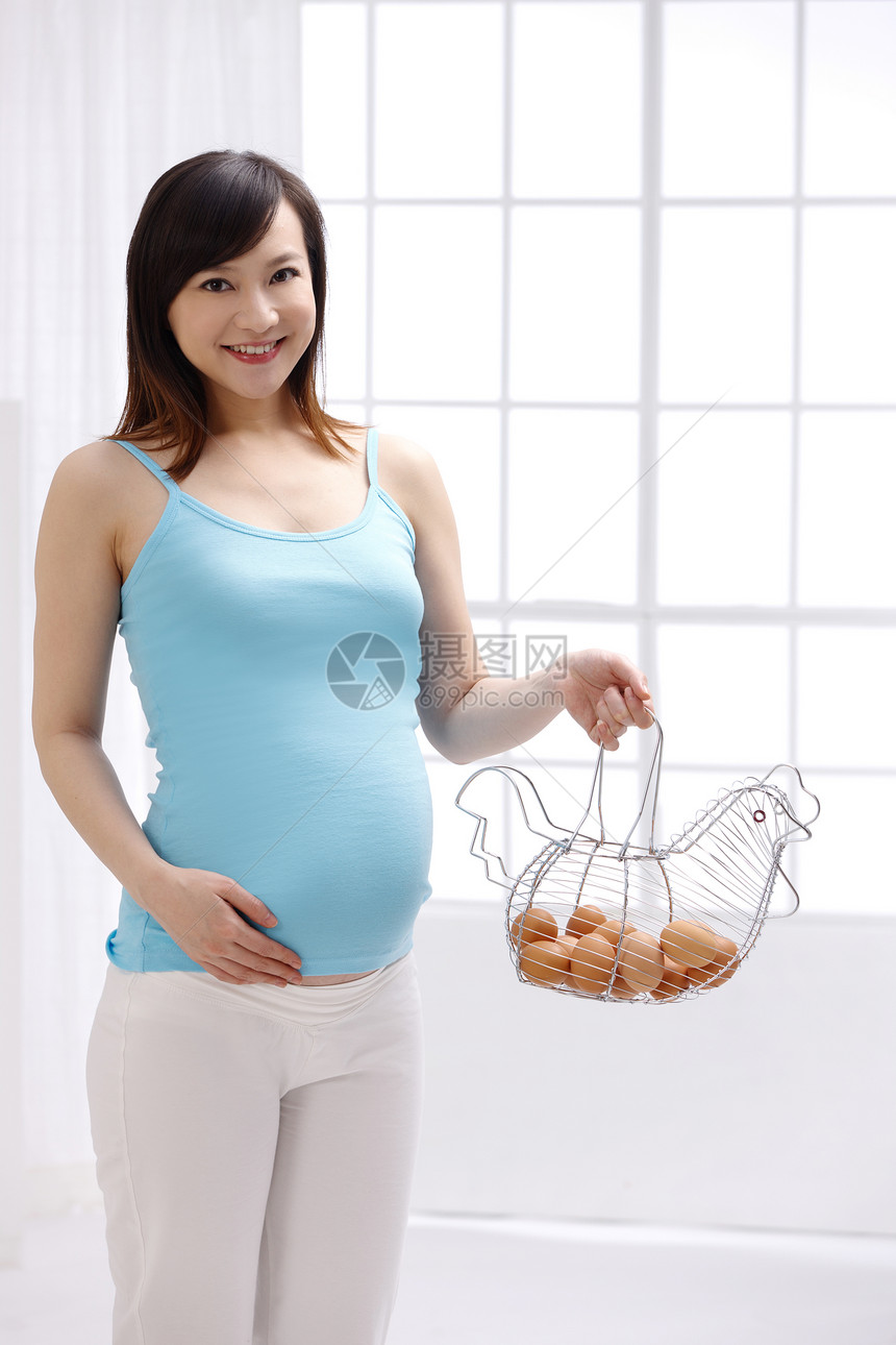 户内女人仅成年人孕妇拿着一筐鸡蛋图片