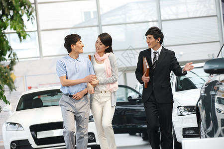 微笑的满意女人青年夫妇在4S点购买汽车高清图片