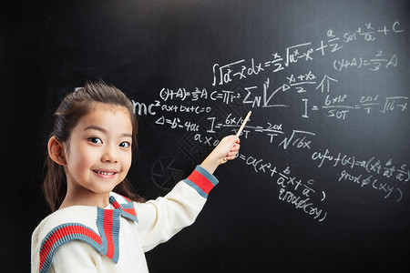 漂亮的未成年小女孩指着黑板上的数学题背景图片