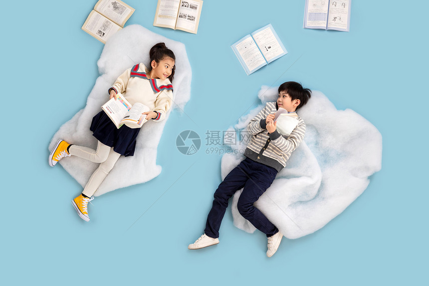 飞童年蓝色背景快乐儿童躺在云彩上看书图片