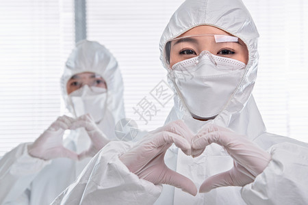 爱心合作素材做手势爱心贡献穿防护服的医疗团队背景