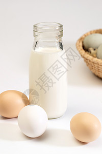 倾倒牛奶瓶玻璃瓶牛奶和蛋类背景