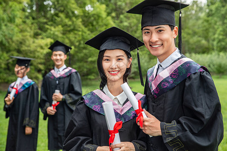 草地上穿着学士服的大学生们毕业高清图片素材