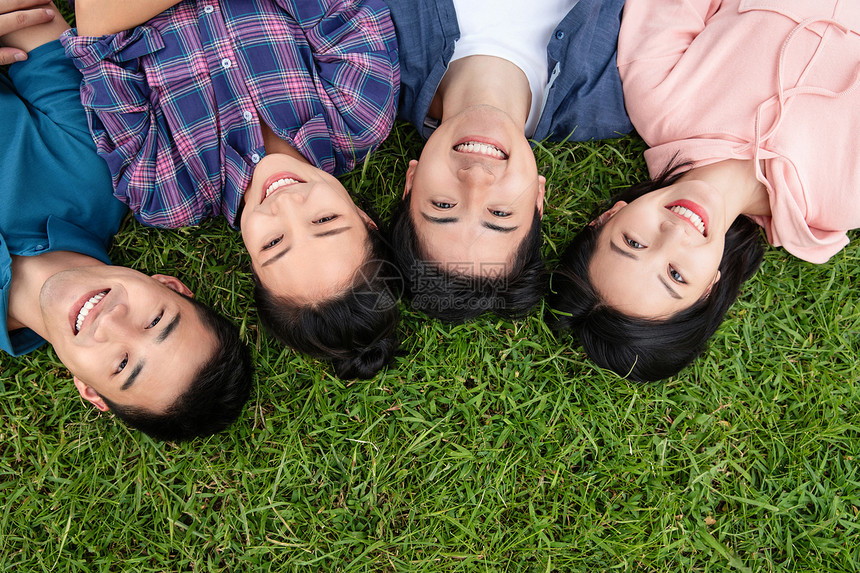 快乐的青年大学生躺在草地上图片