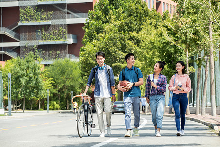 课余活动阳光下快乐的大学生在校园里步行背景