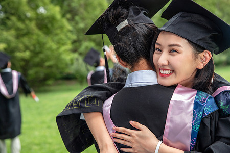 人生大事户外穿着学士服的大学生拥抱告别图片