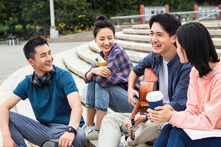 广场上的人年轻的大学生坐在台阶上闲聊背景