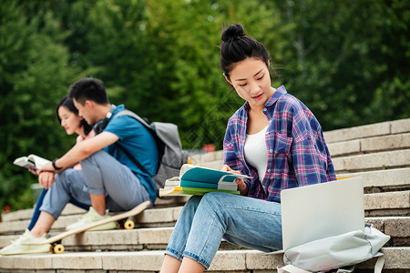 快乐的大学生坐在台阶上学习高清图片