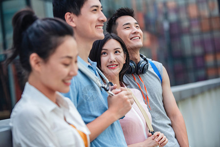 为梦想而快乐的大学生倚栏而站背景