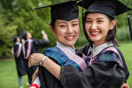 户外穿着学士服的大学生激动的拥抱在一起北京高清图片素材