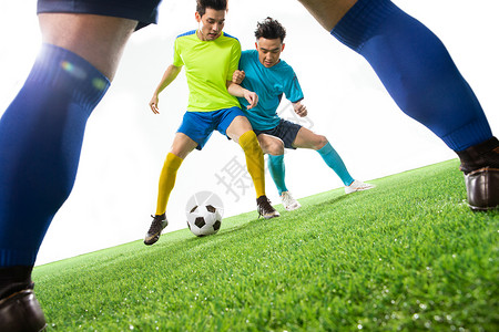 青年男人足球运动员在球场上踢球图片