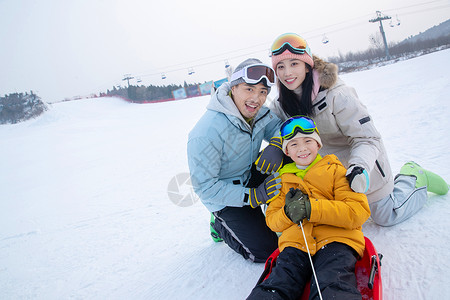 拉着绳子的男孩一家人到滑雪场滑雪运动背景