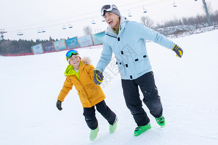 滑雪场内手牵手的快乐父子图片