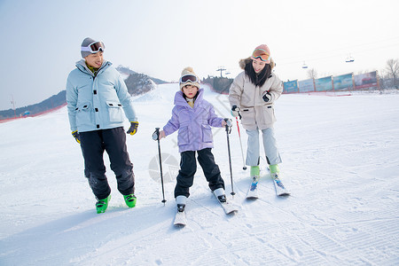 独生子女快乐的一家三口在滑雪场背景