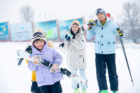 休闲活动放松非都市风光雪场上拿着雪具去滑雪的一家四口关爱高清图片素材