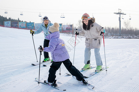 雪场上滑雪的一家三口青年女人高清图片素材