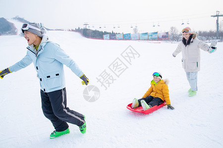 带儿子女儿冬日滑雪的父母雪上滑板高清图片素材