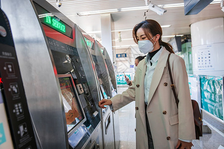 北京地铁站戴口罩的年轻女人在地铁站使用自动售票机背景