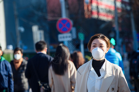 预防冠状病毒肺炎城市生活青年女人戴口罩在户外行走背景