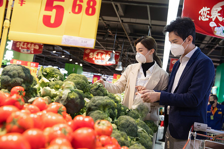 城市生活青年夫妇戴口罩在超市挑选蔬菜高清图片