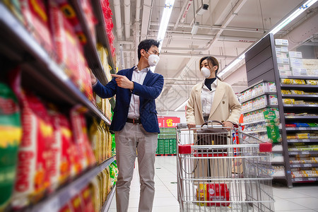 疫情生活戴口罩的青年夫妇在超市购物图片