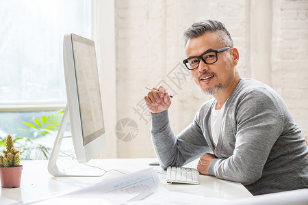 造型仙人掌花在室内研究图纸的中老年设计师男士背景