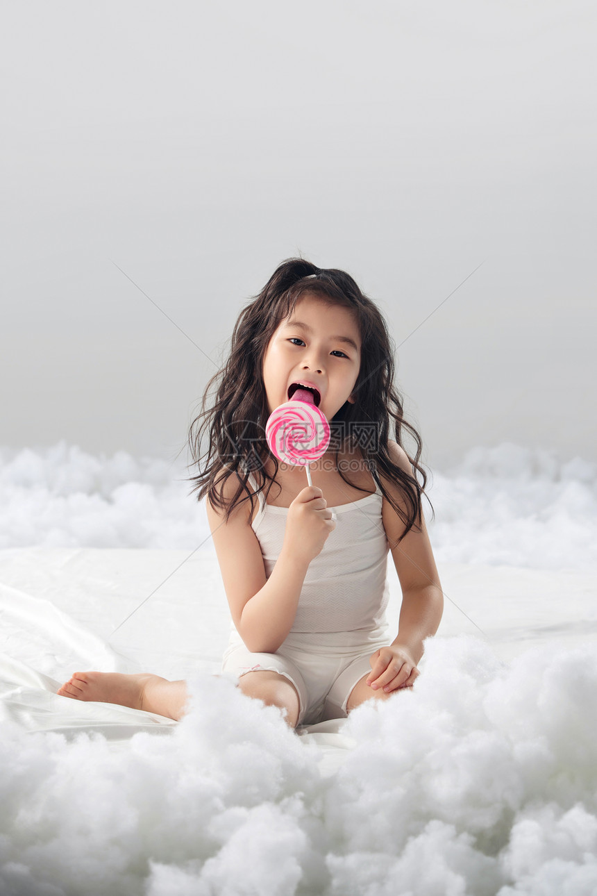 6岁到7岁高兴纯洁吃棒棒糖的可爱小女孩图片