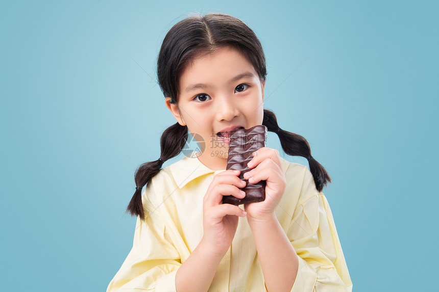 水平构图户内亚洲吃巧克力的小女孩图片