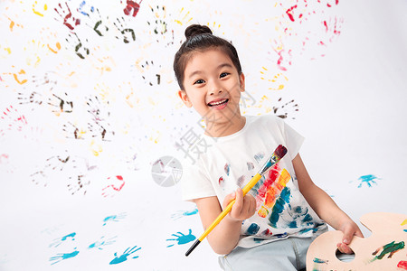 彩色油漆痕迹效果彩色图片柔和影棚拍摄拿画笔画画的小女孩背景