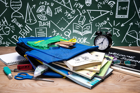 书包铅笔黑板画前的桌子上堆满了学习用品背景