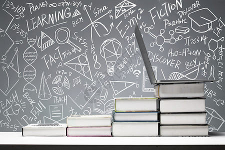 教育灵感黑板画前桌子上的书和笔记本电脑背景