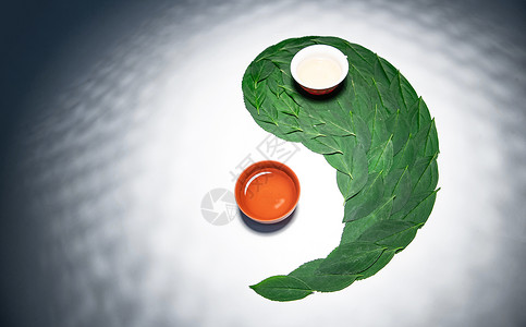 漩涡形阴阳符绿叶茶叶和茶杯组成的太极图案高清图片