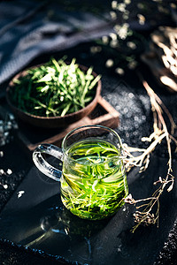 透明玻璃茶杯饮食文化一杯茶水和茶叶背景