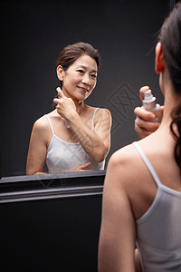 中年女人对着镜子喷香水图片