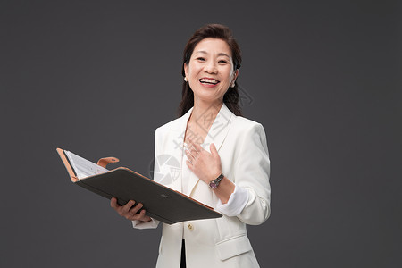 中国画册拿着户型图册讲解的成熟商务女士背景