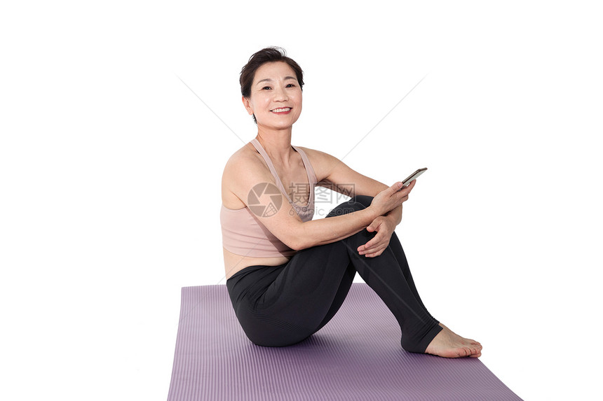 坐在瑜伽垫上休息的中老年女人图片