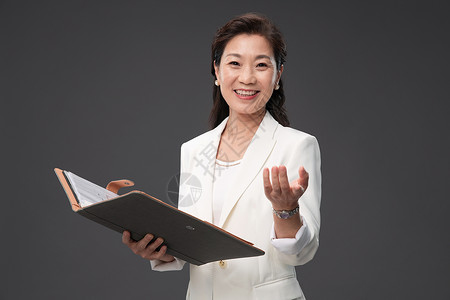 中国画册拿着户型图册做出邀请手势的优雅商务女士背景