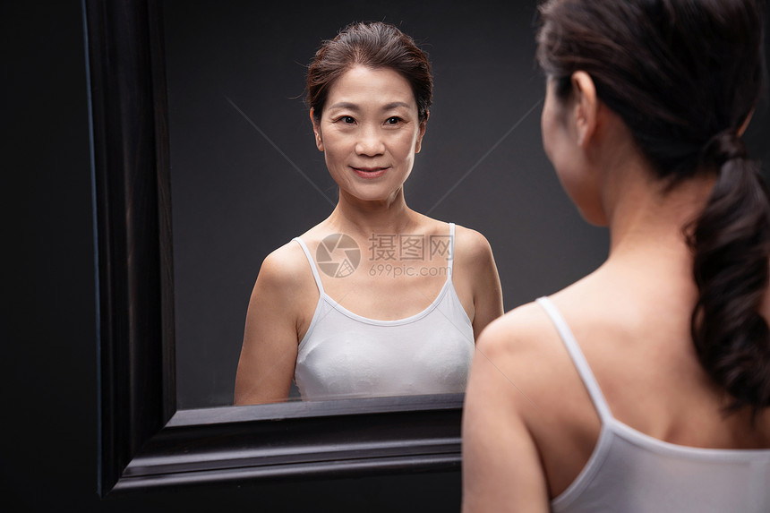 中年女欣赏镜子中的自己图片